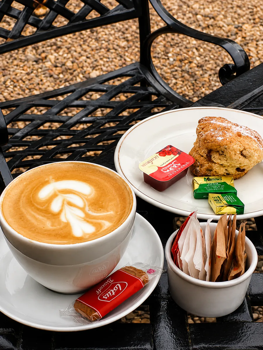 Latte and a scone served on an outdoor table