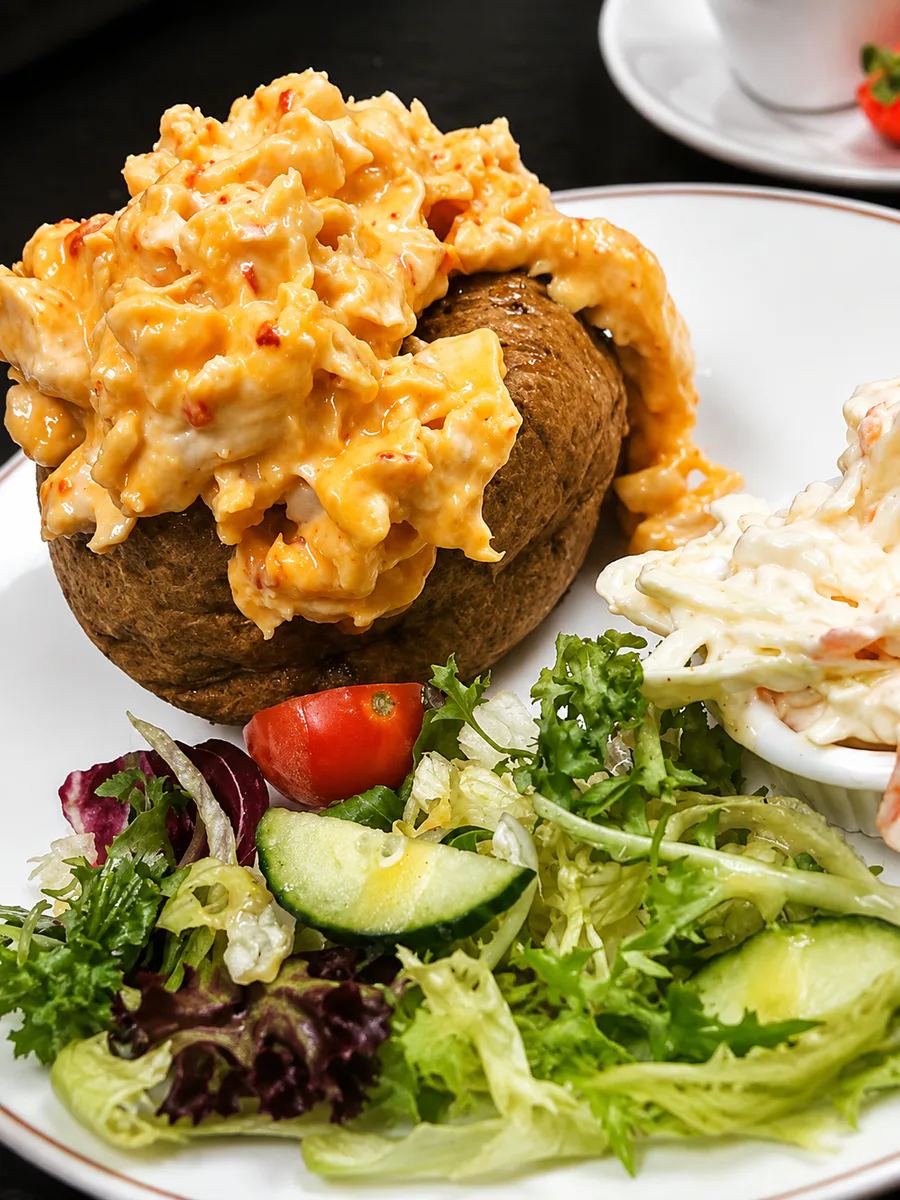 Jacket potato with a creamy topping, salad and coleslaw