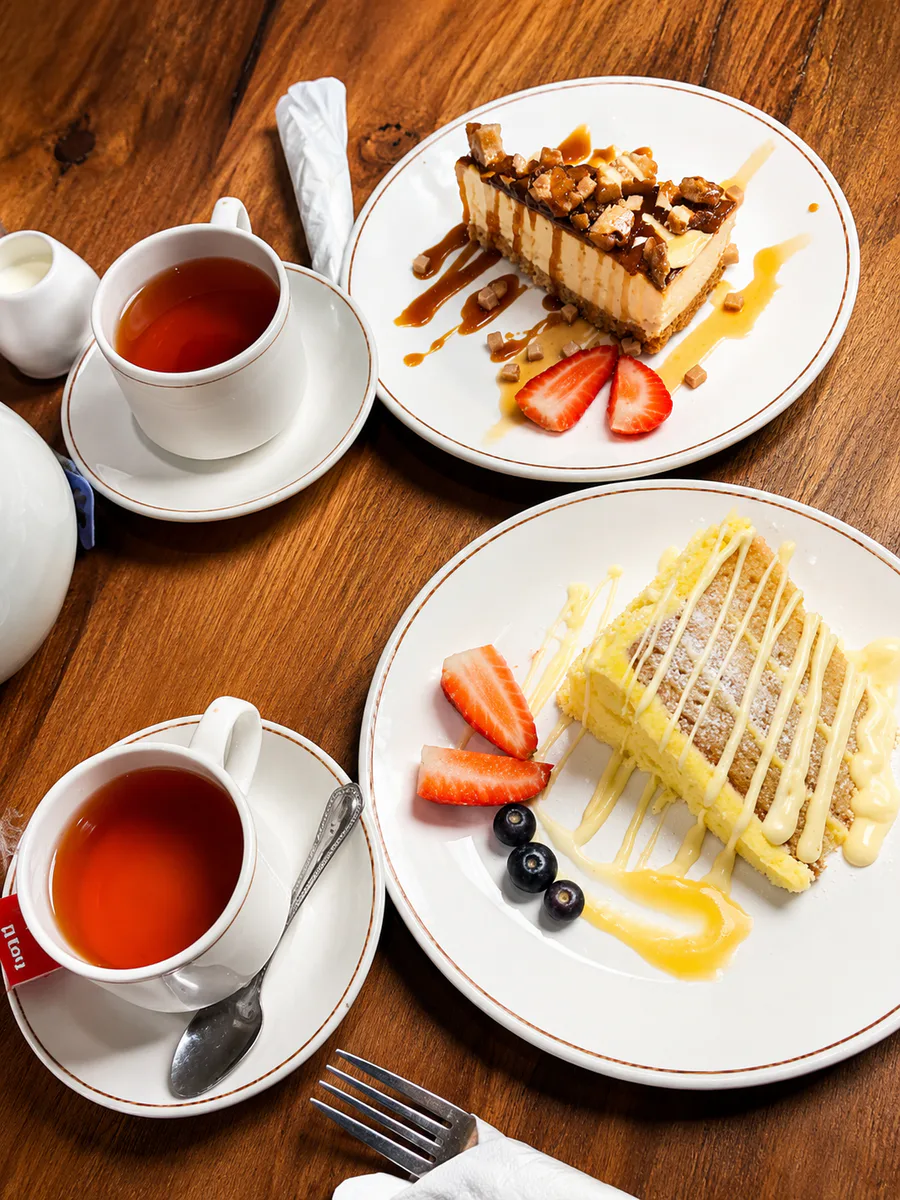Two cups of tea served with slices of cake